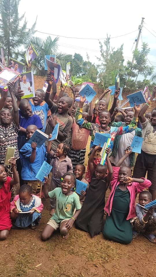 Children celebrating with books and educational materials